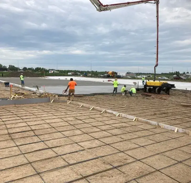 Crew placing a large building slab with a pump truck