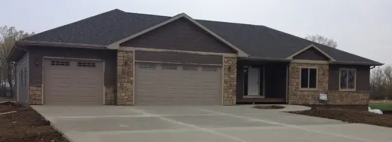 New concrete driveway in front of a stone-accented garage